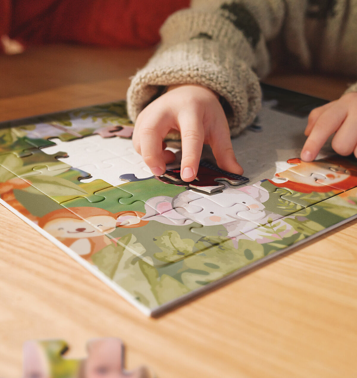 Kind legt ein Fotopuzzle Kids mit Tiermotiv zusammen.