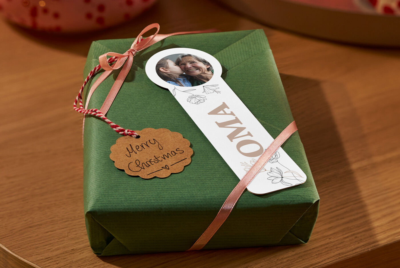 "Liebevoll verpacktes Geschenk mit Schleifen und Foto-Lesezeichen mit der Aufschrift ""OMA"" "