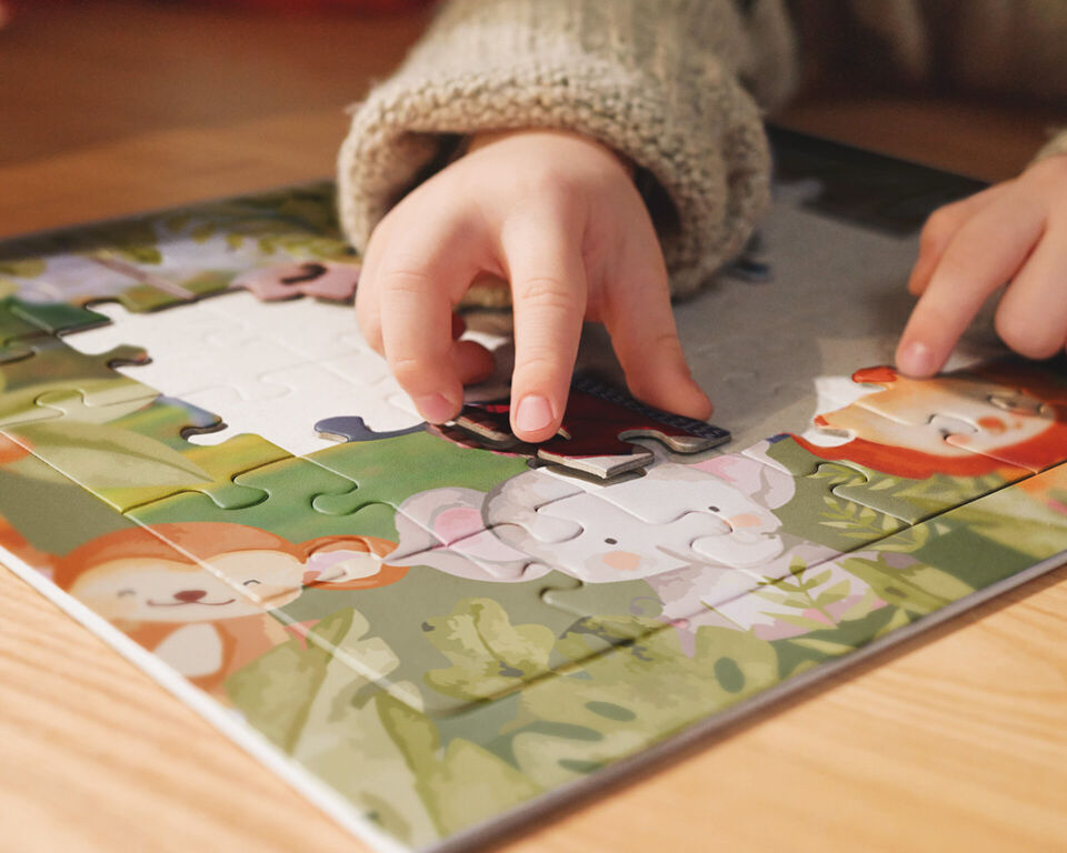 Kind legt ein Fotopuzzle Kids mit Tiermotiv zusammen.