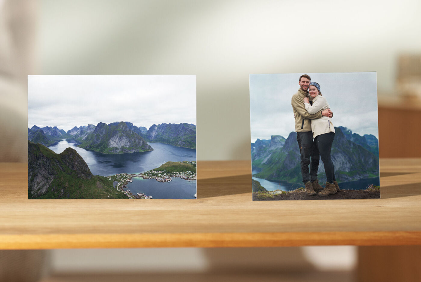 Zwei Fotos auf einem Tisch: ein Landschaftsbild und ein Paar, das sich umarmt.