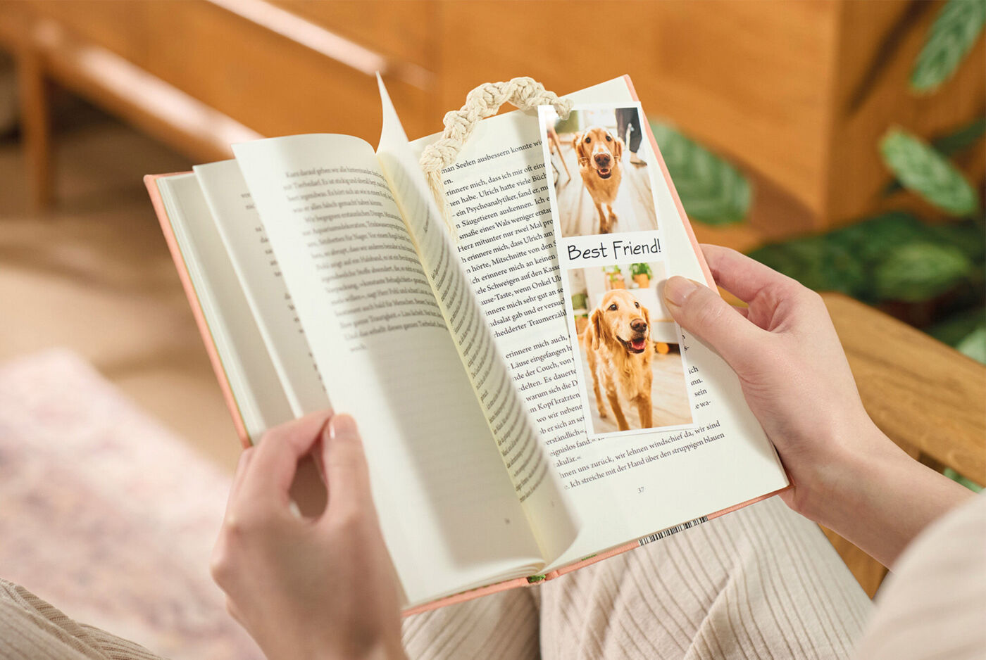 Person hält ein Buch und ein Foto-Lesezeichen mit Hundefotos und der Aufschrift "Best Friend!".