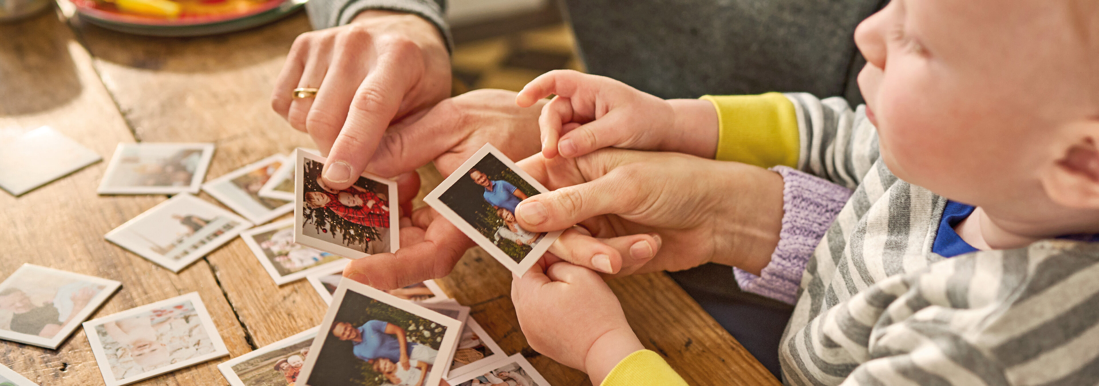 Kind spielt ein personalisiertes Foto-Memory mit einer erwachsenen Person.