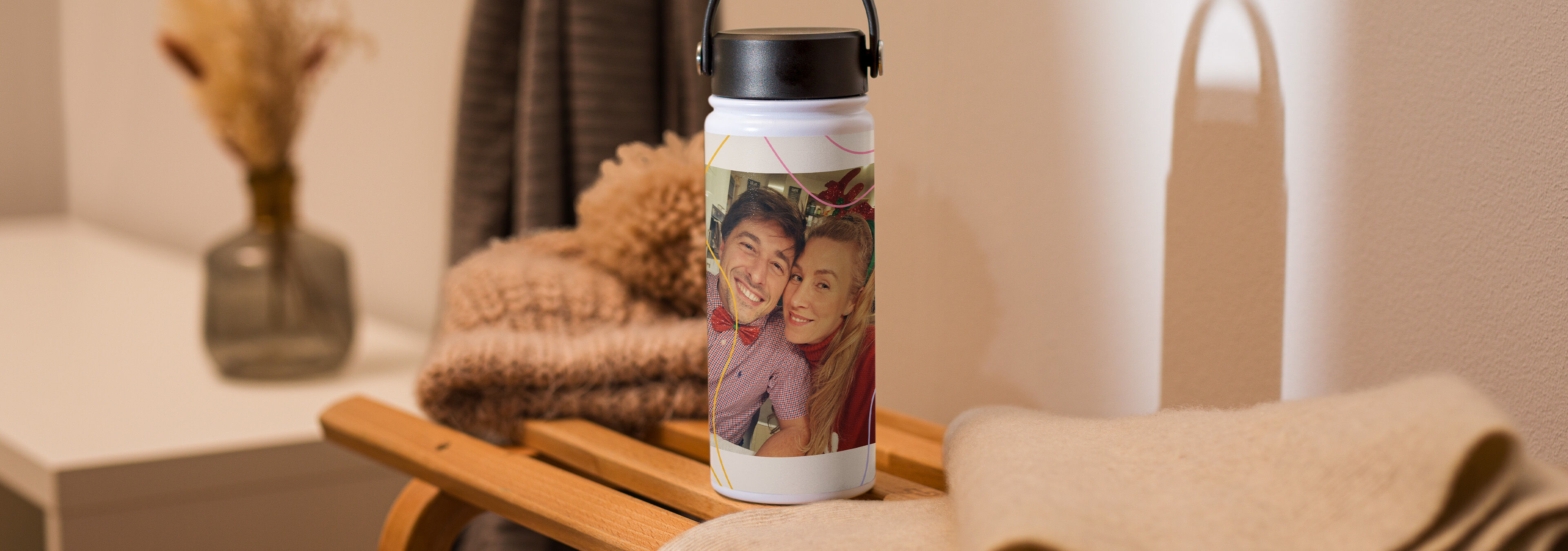 Personalisierte Trinkflasche mit dem Foto eines lächelnden Paares auf einem Holzschlitten