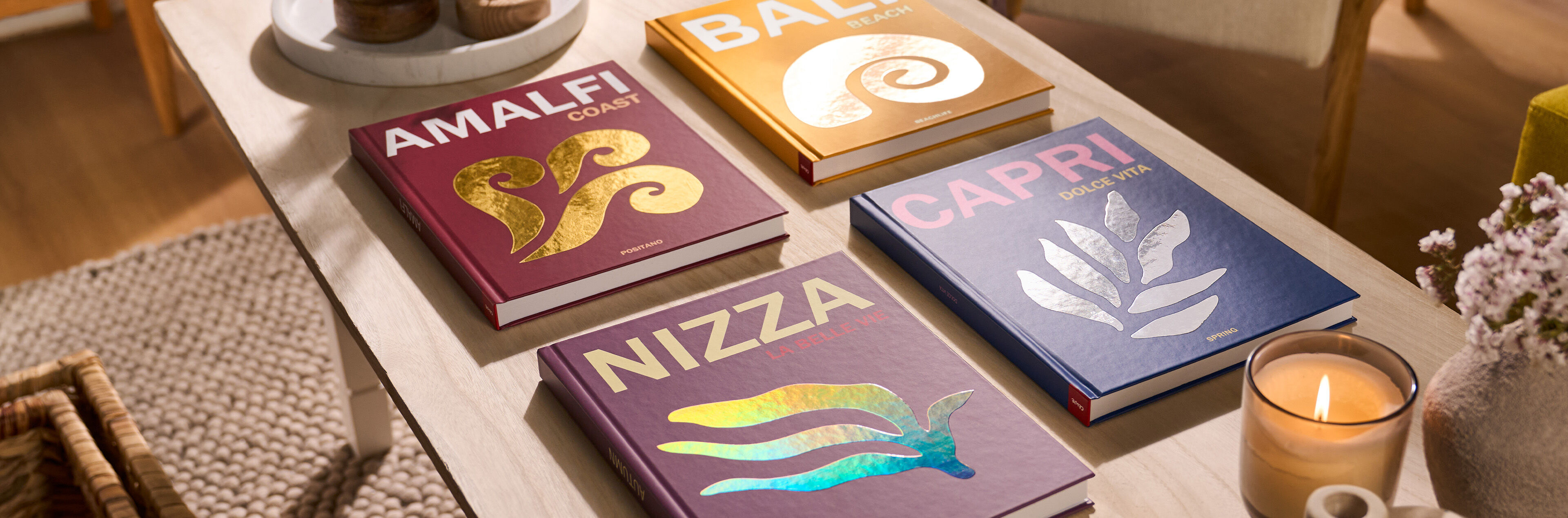 Verschiedene CEWE Fotobücher mit bunten Designs auf einem Tisch.